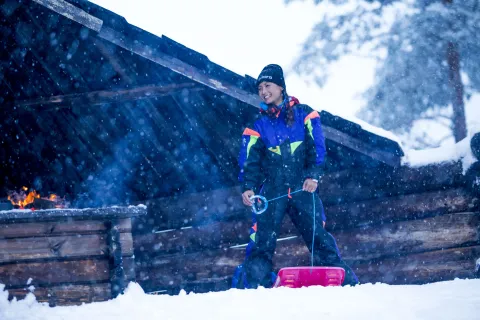 En person i snökläder står i snön