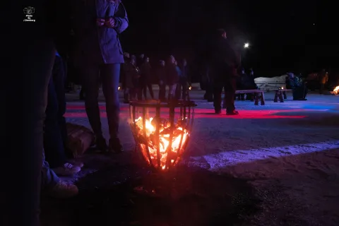 Kväll med människor vid scen och eld vintertid