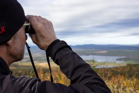 en person som tittar genom kikare